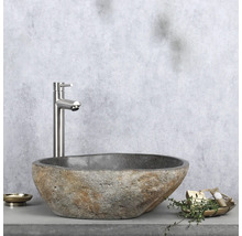 Naturstein-Waschbecken mit Armatur auf Ablage mit Seifenschale und Dekoration