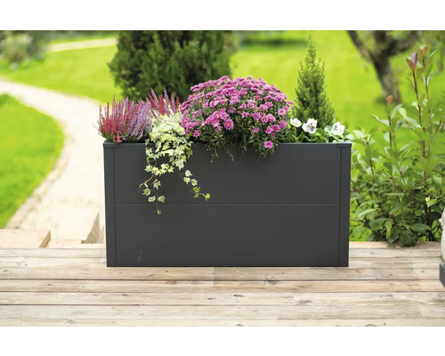Rechteckiger Pflanzkasten aus Metall mit Blumen und Pflanzen auf einer Holzterrasse