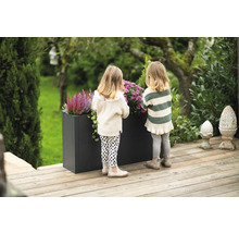 Szene mit zwei Kindern an einem Pflanzkasten im Garten