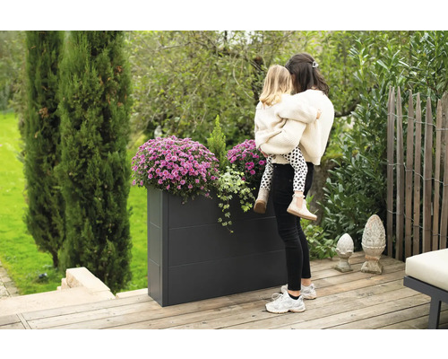 Rechteckiger Pflanzkasten aus Metall mit Blumen und Mutter mit Kind im Garten