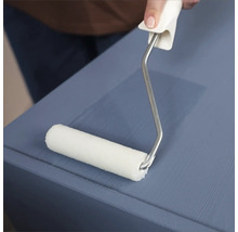 Eine Person verwendet eine Farbwalze, um eine Holzoberfläche zu streichen