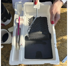 Farbe, Farbroller und Pinsel in einer Farbschale