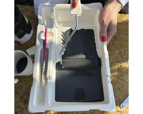 Farbe, Farbroller und Pinsel in einer Farbschale