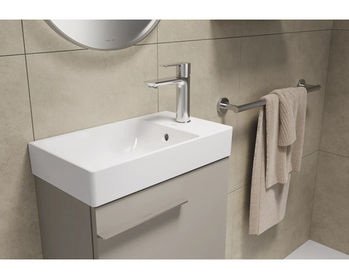 Badezimmer mit Waschbeckenunterschrank, Armatur und Handtuchhalter.