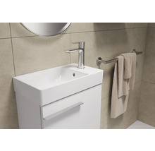 Badezimmerwaschtisch mit Armatur, Handtuch und Handtuchhalter in hellem Badezimmer