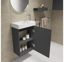 Badezimmer mit Waschbecken, Armatur und offenem Unterschrank zur Aufbewahrung von Badutensilien.