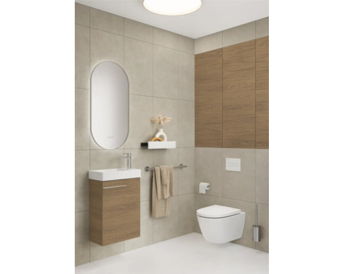 Badezimmer mit Waschtisch, Spiegel, Toilette und Fliesen