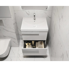 Modernes Badezimmer mit weißem Waschtisch, offenem Schubfach und Marmorfliesen