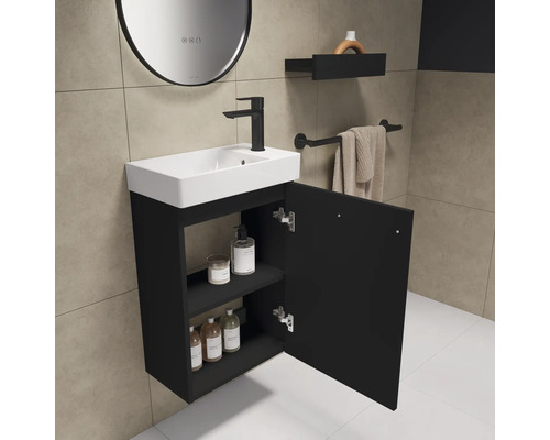 Waschtisch mit offenem Schrank, Armatur, Handtuchhalter und Spiegel in einem Badezimmer