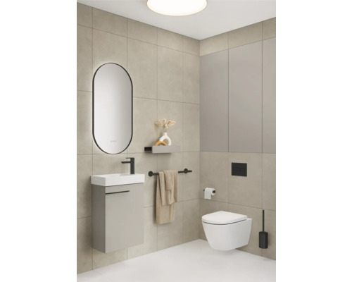 Badezimmer mit Waschbecken, Spiegel, Toilette und Handtuchhalter