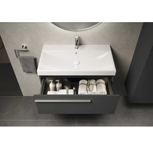 Modernes Badezimmer mit Waschbeckenunterschrank, offenem Schubfach und Handtüchern.