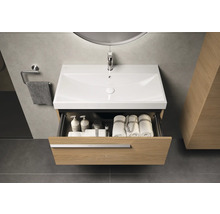 Waschtischunterschrank mit geöffneter Schublade, darin Handtücher und Badutensilien, Armatur und Handtuchhalter im Badezimmer