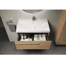 Waschtisch mit offenem Schubfach, darin Handtücher und Pflegeprodukte