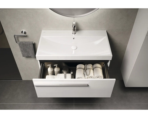 Badezimmer Waschbeckenunterschrank mit offenem Schubfach, inklusive Handtüchern und Badartikeln.