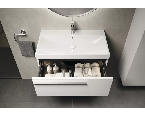 Waschtischunterschrank mit offenem Schubfach, darin Handtücher und Badutensilien