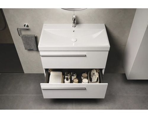 Waschtisch mit offenem Schubfach, Handtuch und Badutensilien im Badezimmer