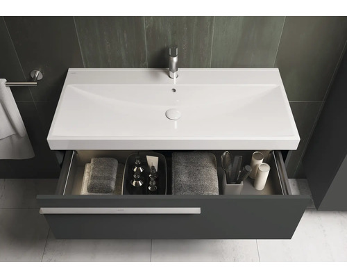 Waschtischunterschrank mit offenem Schubfach, darin Handtücher und Badutensilien