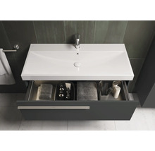 Waschtisch mit geöffneter Schublade, Handtüchern und Badutensilien