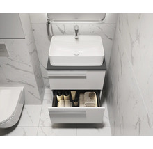 Waschbecken mit Unterschrank und offener Schublade im Badezimmer