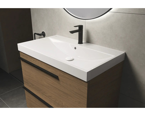 Waschtisch mit Unterschrank und Armatur im Badezimmer.