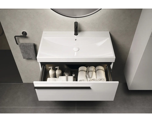 Waschtischunterschrank mit offenem Schubfach, Handtüchern und Pflegeprodukten im modernen Badezimmer