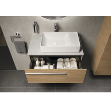 Badezimmer mit Waschbecken, Waschtischunterschrank mit Schublade, Handtüchern und Badutensilien