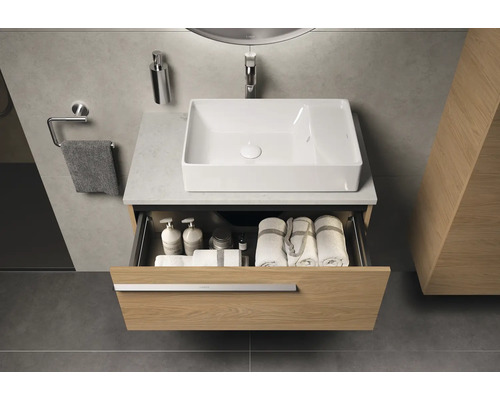 Badezimmer mit Waschbecken, Waschtischunterschrank mit Schublade, Handtüchern und Badutensilien