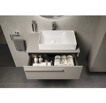 Modernes Badezimmer mit Waschbecken, offenem Schubladenelement und Badezimmerutensilien