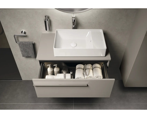 Modernes Badezimmer mit Waschbecken, offenem Schubladenelement und Badezimmerutensilien