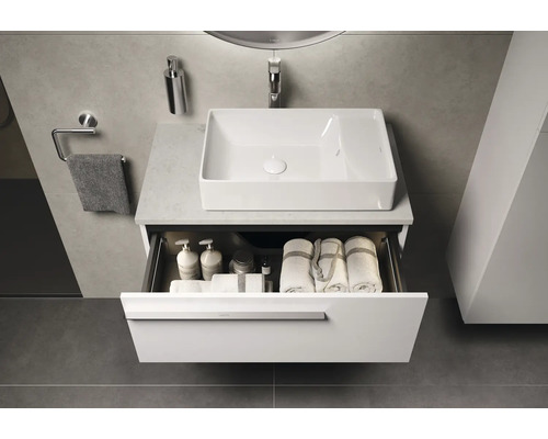 Badezimmer mit Waschbecken, offenem Unterschrank mit Handtüchern und Pflegeprodukten