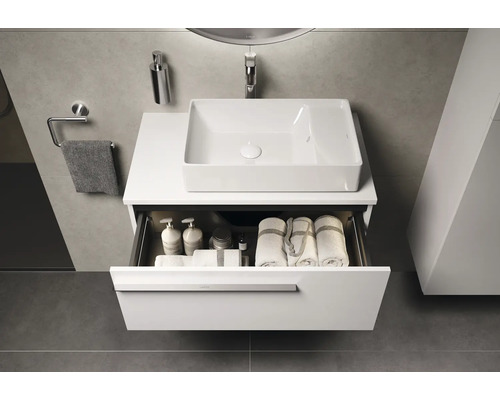 Modernes Badezimmer mit Waschtisch, Waschbecken und offenem Schubladenfach mit Handtüchern und Badutensilien.