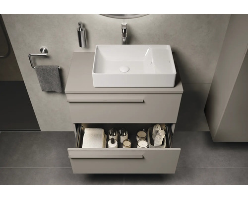 Badezimmer mit Waschbecken, Unterschrank und offenem Schubfach zur Aufbewahrung von Badutensilien