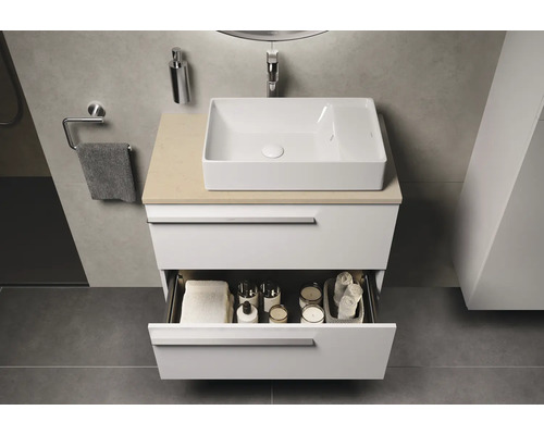 Modernes Badezimmer mit weißem Waschtischunterschrank und offenem Schubladen mit Badutensilien.