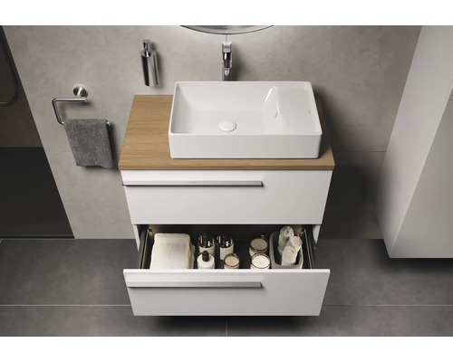 Badezimmer mit Waschbecken, Holzplatte und offenem Schubfach zur Aufbewahrung von Handtüchern und Kosmetikartikeln