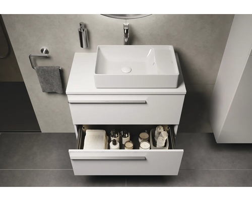 Modernes Badezimmer mit Waschbecken, Unterschrank und offener Schublade mit Badutensilien.