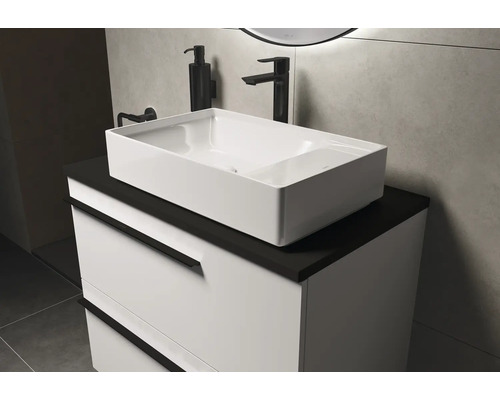 Waschtisch mit Aufsatzwaschbecken, Armatur und Seifenspender im Badezimmer.