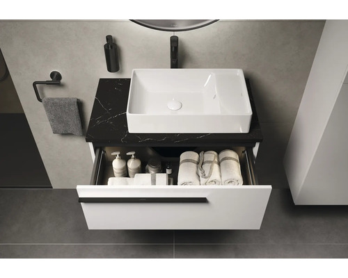 Modernes Badezimmer mit Waschbecken, schwarzer Arbeitsplatte und offenem Schubfach zur Aufbewahrung von Badutensilien