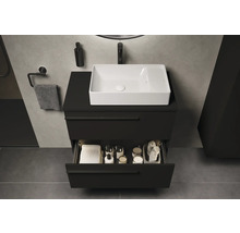Badezimmer mit schwarzem Waschtischunterschrank, weißem Aufsatzwaschbecken und geöffneter Schublade mit Badutensilien