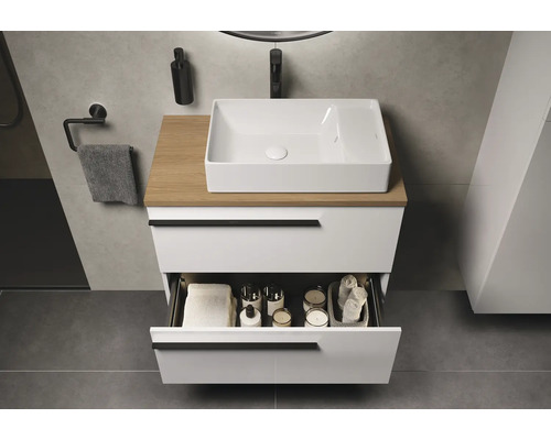 Badezimmer mit Waschbecken, Holzplatte und offenem Schubfach mit Badutensilien