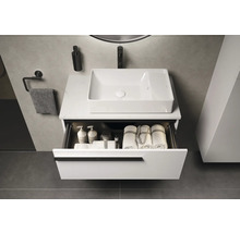 Modernes Badezimmer mit Waschtisch, rechteckigem Aufsatzwaschbecken und geöffneter Schublade mit Handtüchern und Pflegeprodukten.
