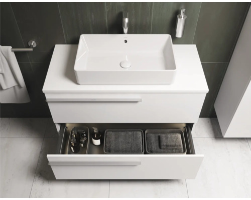 Modernes Badezimmer mit weißem Waschtischunterschrank, Aufsatzwaschbecken und geöffneter Schublade mit Badutensilien