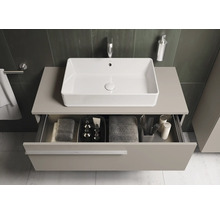 Badezimmeransicht mit Waschbecken und offenem Schubladenfach unter der Arbeitsplatte, in der Handtücher und Badutensilien aufbewahrt werden.