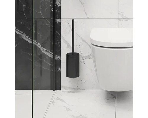 Schwarze Wand-Toilettenbürste neben einer Toilette an einer gefliesten Wand.