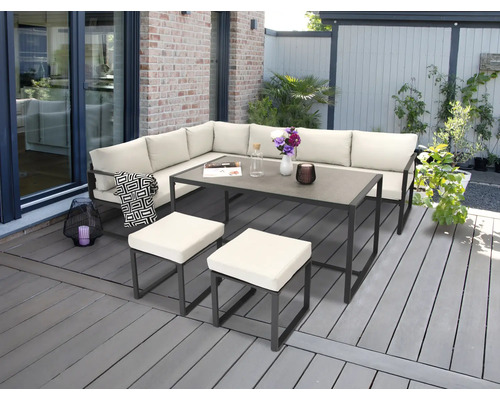 Gartensitzgruppe mit Ecksofa, Tisch und Hockern auf einer Terrasse