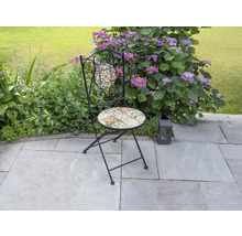 Gartenszene mit einem Klappstuhl mit Mosaikmuster
