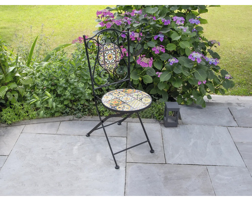 Gartenszene mit einem Klappstuhl mit Mosaikmuster