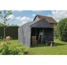 Graues Lagerzelt im Garten mit Leiter, Rasenmäher und Holzkisten