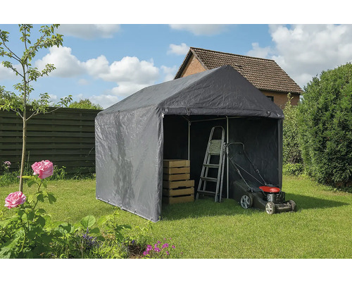 Graues Lagerzelt im Garten mit Leiter, Rasenmäher und Holzkisten