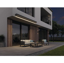 Moderne Hausfassade mit beleuchteter Markise, Gartenmöbeln und Terrasse