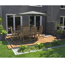Gartenszene mit Esstischgruppe unter einem Sonnenschirm auf einer Holzterrasse